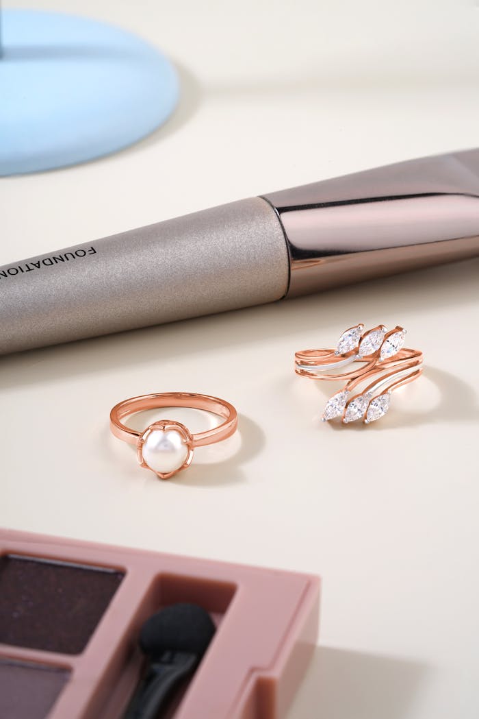 A chic display of pearl and diamond rings with makeup accessories.