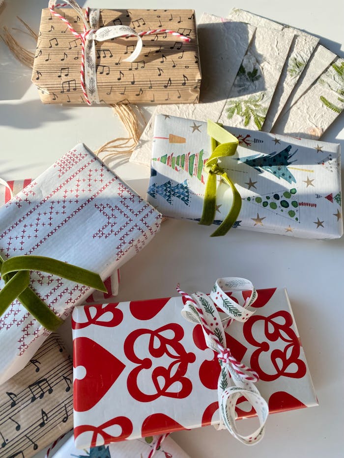 Festive Christmas-themed gift wrapping papers with musical notes and tree designs in bright sunlight.